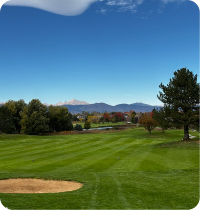 A golf fairway with mountains behind it.